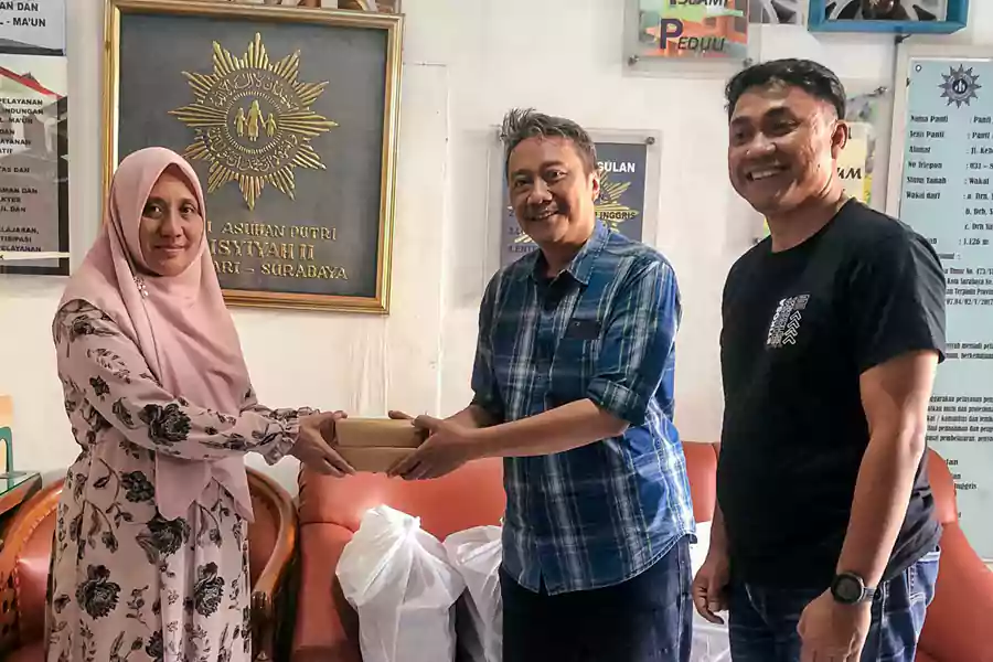 Alumni Stikosa AWS membagikan nasi kotak makan siang gratis.