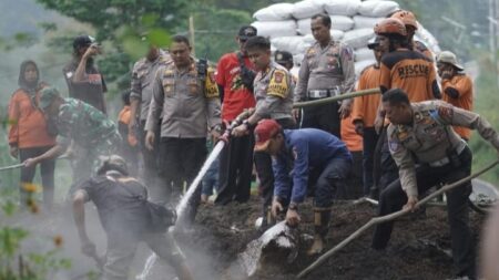 Kasat Lantas Polres Mojokerto, AKP Muhammad Hariyazie bersama personel gabungan memperbaiki tumpukan sekam di jalur penyelamat turunan Gotekan, Desa Pacet, Kecamatan Pacet, Kabupaten Mojokerto. [Foto : ist]