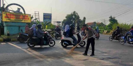 Personil Unit Lantas Polsek Gedeg membersihkan tumpahan minyak tumpahan minyak solar di Jalan Raya Gedeg. [Foto : ist]