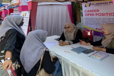 Pelamar kerja sedang berbincang dengan perwakilan perusahaan yang membuka stan di Job Fair di halaman SMK Kesehatan Bina Karya Medika. (Foto/Istimewa)