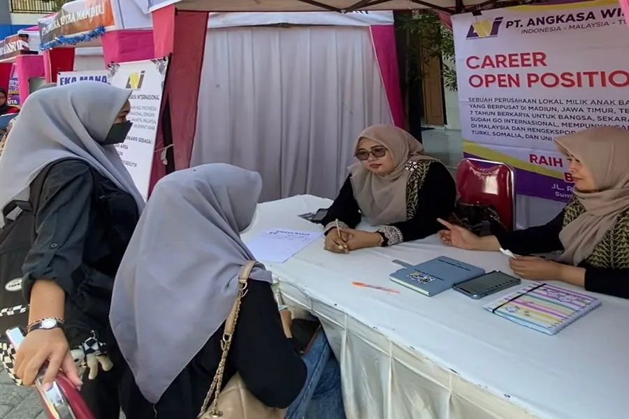 Pelamar kerja sedang berbincang dengan perwakilan perusahaan yang membuka stan di Job Fair di halaman SMK Kesehatan Bina Karya Medika. (Foto/Istimewa)