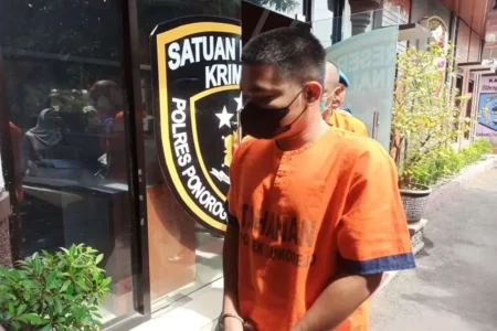 Pelaku AS yang digelandang dari kantor Satreskrim Polres Ponorogo. (Foto/Endra Dwiono/Beritajatim.com)