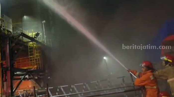 Foto dua petugas damkar berjibaku memadamkan api yang melalap unit asal sulfat PT Freeport Indonesia di KEK Gresik.