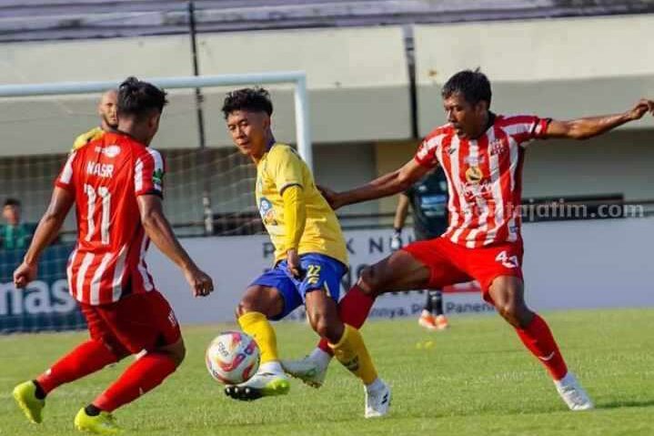 Gelandang Gresik United Ibnu Hajar (kuning) diapit dua pemain Deltras FC. (Foto: Gresik United)