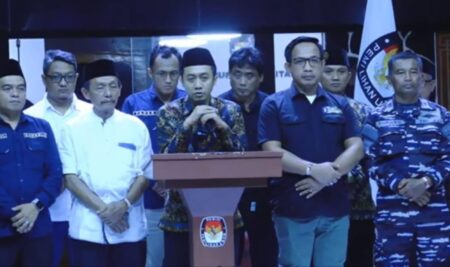 Tangkapan Layar saat ketua KPU Aswika Budhy Arfandy mengumumkan keputusan untuk membatalkan debat perdana didampingi perwakilan masing-masing paslon (Istimewa/beritajatim.com)