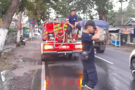 Petugas Satpol PP dan Damkar Bondowoso membersihkan tumpahan solar di Desa Dadapan hingga Kelurahan Nangkaan, Senin (30/9/2024) sore. (Hum/Kar)