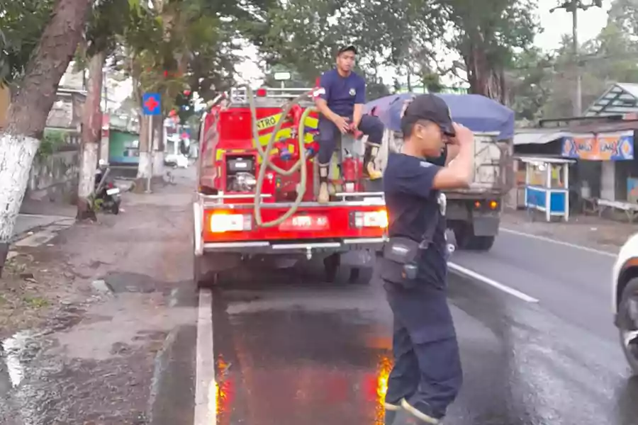 Petugas Satpol PP dan Damkar Bondowoso membersihkan tumpahan solar di Desa Dadapan hingga Kelurahan Nangkaan, Senin (30/9/2024) sore. (Hum/Kar)