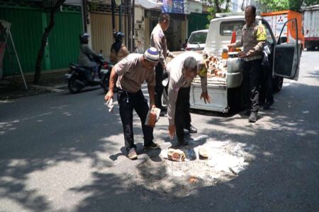 Jalan Berlubang di Jalur Nasional Tak Kunjung Diperbaiki, Satlantas Polres Pasuruan Turun Tangan Foto BeritaJatim.com
