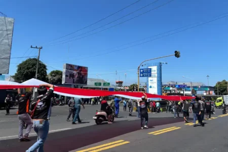 Bentangkan Merah Putih 500 Meter, Sopir Truk Protes Macet dan Pungli di Pelabuhan Ketapang Banyuwangi Foto BeritaJatim.com